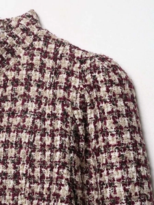 Detailed close-up of wine red houndstooth tweed texture on a classic short jacket
