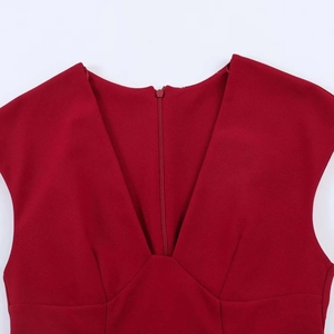 Detail view of deep V-neck and invisible back zipper on red sleeveless dress