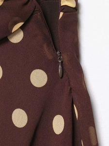 Detail showing high-quality side hidden zipper on brown polka dot chiffon skirt