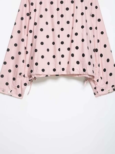Detail of pink polka dot jacket with adjustable drawstring hem and buttoned cuffs