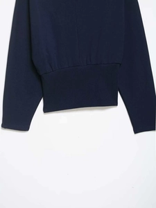 Detailed macro view of dark blue cotton sweatshirt fabric with ribbed hem and neat stitching