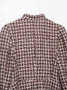 Detail of burgundy houndstooth pattern fabric with stand collar on wool blend jacket