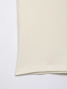 Close-up of cream white ribbed knit fabric showing vertical texture and clean hemline