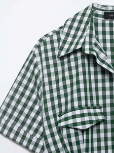 Close-up detail of green and white gingham shirt dress with collar and breast pocket