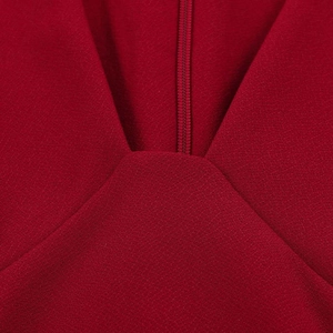 Detailed close-up of V-neck seam and invisible zipper on red sleeveless A-line dress