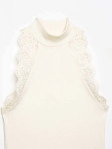 Detailed view of cream knit sleeveless top with high neck and delicate lace trim