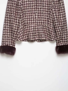 Detail of red and white houndstooth wool coat with burgundy faux fur cuffs and texture
