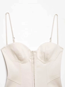 Detalle de un top de corsé beige con escote corazón y costuras estructurales