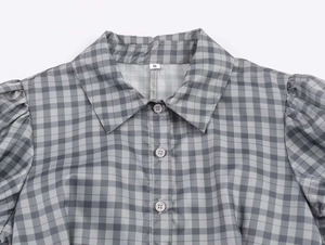 Close-up of gray and white checkered short dress featuring puff sleeves and size S tag