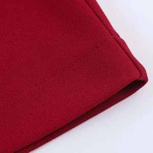 Close-up of dark red V-neck dress fabric showing fine textured grain and quality stitching