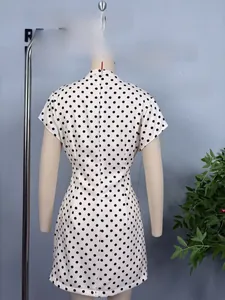 Detail of white polka dot dress featuring a slim waist cut and back zipper closure