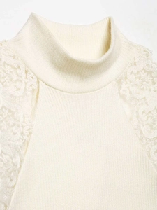 Detailed close-up of cream knit top featuring elegant lace patchwork on the shoulder part
