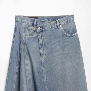 High-waisted asymmetric denim skirt in classic wash blue with overlap waist design