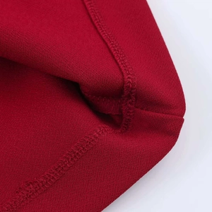 Detail view of the inner seam and overlock stitching on the dark red V-neck dress