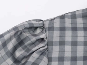 Detail of puffed sleeves with pleated design on a grey gingham check summer dress