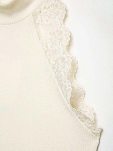 Detailed macro view of white knit top armhole featuring delicate layered lace ruffles