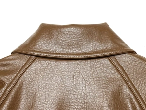 Macro shot of brown faux leather collar with natural texture and fine stitching detail