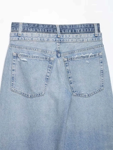 Vue détaillée du dos d'un jean bleu clair à double taille avec poches usées et texture délavée