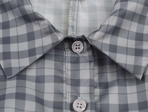 Close-up of the collar and gray checkered fabric detail with four-hole buttons on the dress