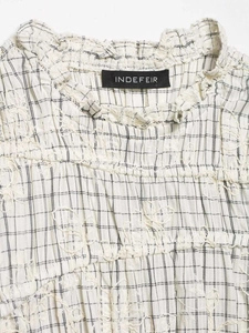Detail of white checkered fabric with elegant floral embroidery and brand label