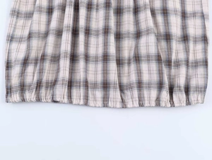 Close-up of vintage plaid shirt fabric featuring elastic hem and smocked details