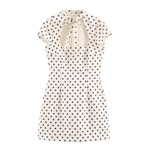 Detail of white polka dot short dress with bow tie collar and teardrop cutout design
