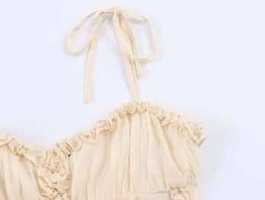 Close-up of beige camisole with lettuce trim, delicate buttons and tie straps detail