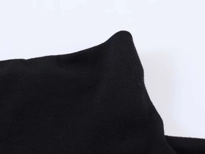 Detailed close-up of the black knitted turtleneck dress with ribbed texture and finish