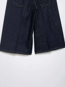 Detail of dark blue wide-leg denim jeans featuring yellow contrast stitching and back pockets