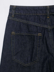 Detailed view of dark blue denim stitching and rear pocket on loose fit jeans