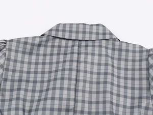 Detail of grey gingham summer dress featuring a crisp collar and puffed shoulder design