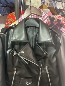 Vue détaillée des poches zippées et du col à revers sur la veste en similicuir noir chic