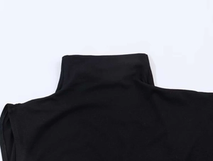 Detailed view of black mock neck knitted top with fine vertical ribbed texture