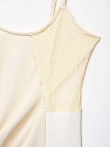 Détail de la dentelle florale délicate et du tissu soyeux crème sur le caraco femme