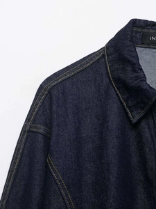 Macro detail of dark blue denim jacket collar with high-density gold stitching