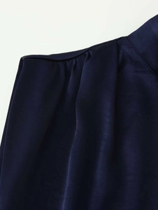 Détail des plis d'épaule sur une robe sans manches en satin bleu foncé soyeux