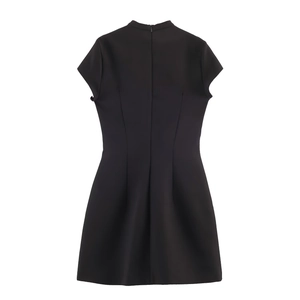 Close-up of the back zipper and waist pleated detail on a black high-neck dress