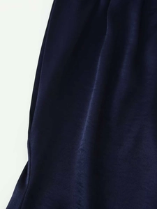 Gros plan détaillé du tissu en satin bleu marine montrant une texture soyeuse de luxe