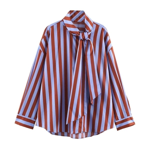 Detail of loose-fit striped shirt with vertical brown stripes and bow-tie neckline