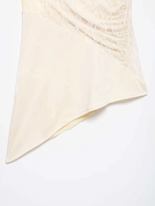 Gros plan détaillé sur le patchwork de dentelle crème et la texture florale du top