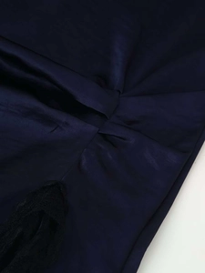 Vue détaillée du satin bleu marine avec textures plissées et bordure en dentelle noire