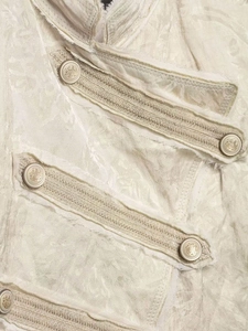 Detail of vintage jacquard fabric with ornate floral patterns and embossed crest buttons