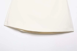 Detailed close-up showing the high-waisted white A-line skirt hem with clean stitching