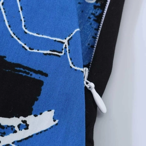 Detailansicht des weißen nahtverdeckten Reißverschlusses am Rock mit Print