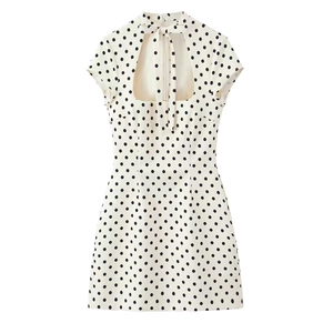 Detailed view of polka dot dress with high neck tie and teardrop cutout design