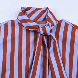 Detail view of the striped shirt's mandarin collar and bow tie-up neck design