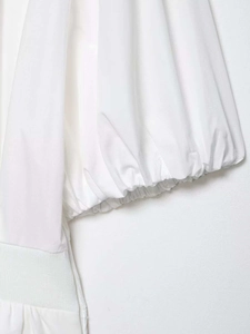 Detailed view of white puff sleeve cuff and elastic pleated waist on a dress