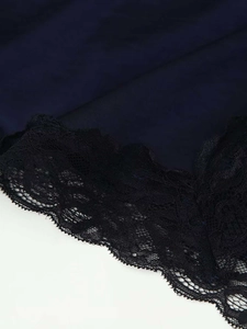 Détails macro de la dentelle noire et du tissu soyeux sur une robe d'été sans manches