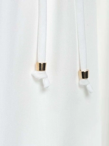 Detail of white cotton shirt dress showing drawstring waist and gold metal aglets