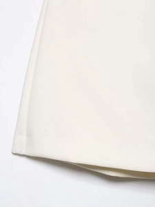 Detail view of the high-waisted white skirt showing precision stitching and fabric texture